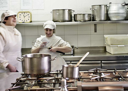 Dos mujeres con discapacidad intelectual, trabajando en una cocina
